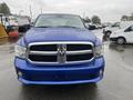 A blue 2019 RAM 1500 Classic with a distinctive front grille and bold headlights parked in a wet area