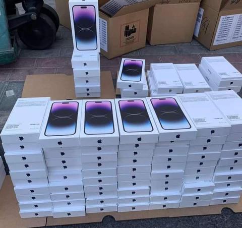 A stack of Apple iPhone 14 Pro Max boxes with the front display showing a purple gradient design