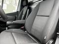 Interior view of a 2021 Mercedes-Benz Sprinter showing two black fabric seats with a modern design and adjustable armrests