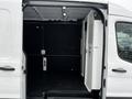 Interior of a 2021 Ford Transit van showcasing a spacious cargo area with black walls and a partitioned section on one side