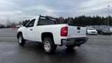 A 2013 Chevrolet Silverado 1500 in white with a short bed and chrome wheels parked in a lot