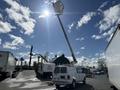 A white 2008 Ford Econoline van with a raised aerial lift extending upward toward a bright sun in a blue sky