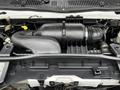 A 2009 Ford Econoline engine featuring a large black air intake and various components including hoses and connectors