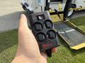 A hand holding a black Ricon lift control remote with several buttons labeled for power and lift functions