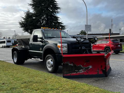 A black 2012 Ford F-550 with a red snowplow attachment in the front