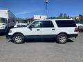 A 2013 Ford Expedition in white with black accents and a boxy shape visible from the side