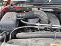 The engine compartment of a 2012 RAM 2500 showing the air filter housing and intake hoses with visible wear and dust accumulation