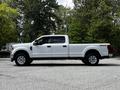A 2020 Ford F-350 Super Duty pickup truck in white color with a crew cab and four-wheel drive features a long bed and chrome wheels