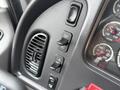 Controls and gauges of a 2016 Freightliner 108SD with buttons for cruise control and air conditioning visible on the dashboard