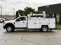 A white 2017 Ford F-550 with a utility body and mounted equipment on the bed including a crane mechanism and a round tank