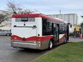 A 2016 Grande West Vicinity bus with a red and white design is parked with its rear facing the viewer showing the vehicle number 2041