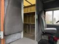 Two gray driver seats occupy the front of a 2012 Ford Econoline with a spacious, empty cargo area visible behind them