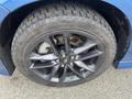 Close-up of a black, five-spoke alloy wheel with a performance tire from a 2022 Dodge Charger