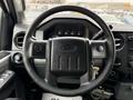 Black steering wheel of a 2013 Ford F-550 with controls and dials visible on the dashboard