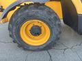 A close-up of a large yellow tire from a 2013 JCB 510-56 Loadall showing rugged tread pattern and a rim with a central hub