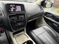 Interior view of a 2017 Dodge Grand Caravan featuring a dashboard with a touchscreen display climate controls and leather seating
