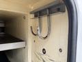A pair of metal hooks mounted on a wall inside a compartment of a vehicle
