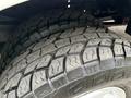 Close-up of two rugged tires mounted on a 2001 Ford F-350 showing deep tread patterns for traction