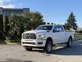 A white 2023 RAM 3500 truck with chrome accents and a large front grille parked on a driveway