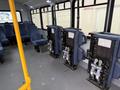 Interior view of a 2017 Chevrolet Express showing several rows of blue upholstered seats with folding mechanisms attached to the floor