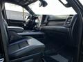 Interior view of a 2019 RAM 1500 featuring black leather seats a modern dashboard and a large touchscreen display in the center console