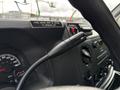 Close-up of the interior dashboard of a 2017 Ford Econoline showing the steering wheel controls speedometer and gear shift area