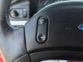 Close-up of a black steering wheel with a switch labeled On and Off on the left side of the wheel