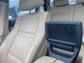Interior view of a 2009 BMW X5 featuring beige leather seating and a central display screen in the console area