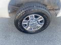 Close-up of a black tire with shiny silver rim featuring the Ford logo on a 2014 Ford F-250 SD