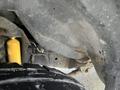 Close-up view of the undercarriage of a 2009 Ford Econoline showcasing a yellow shock absorber and part of the suspension system