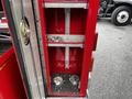Interior compartment of a 1991 Sutphen Deluge fire truck featuring metal shelves and two metal couplings on the bottom