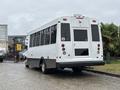 A white 2020 Chevrolet Express with large windows and a rear ramp for accessibility parked at an angle