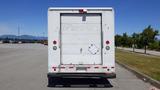 A white 2006 Ford Econoline cargo van with a rear loading door and a small side door, featuring a simple design and some wear on the bumper