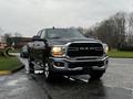 A 2020 RAM 3500 truck with a black exterior and chrome accents parked on a wet road