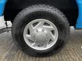 A close-up of a silver wheel and tire from a 2009 Ford Econoline with the tire brand Goodyear Wrangler visible on the sidewall