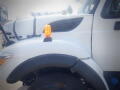 Close-up of a white 2016 International WorkStar 7500 truck showing the front fender and orange clearance light