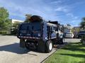 A blue 2007 International 7300 truck with a flatbed and a hydraulic lift at the back parked on a paved area