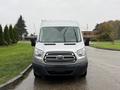 A silver 2019 Ford Transit van viewed head-on with a prominent grille featuring the Ford logo and large windshield wipers