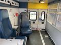 Interior of a 2014 Chevrolet Express with blue seating and medical equipment including cabinets and a console