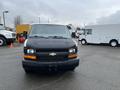 A 2012 Chevrolet Express van with a black exterior and a silver Chevrolet emblem on the front grille