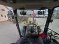 Interior view of a 2015 Case 590SN tractor with a steering wheel control panel and seat visible from the operator's perspective