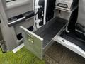 A silver metal drawer is extended from the side of a 2017 Ford F-150 pickup truck's interior