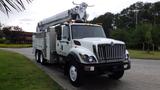 A 2012 International 7400 truck equipped with a boom lift and utility compartments on the side