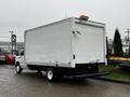 A 2017 Ford Econoline van with a white box truck body facing away from the viewer showcasing its rear and side features