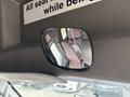 A rearview mirror reflecting the interior of a 2014 Ford E-350 van with pink upholstery visible in the image