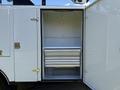 An open compartment of a 2023 Ford F-550 featuring metal drawers and shelves designed for storage and tools