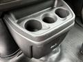 A black cup holder with three circular compartments designed to hold drinks in a vehicle