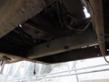 A 2015 Vermeer Corporation BC1200XL wood chipper viewed from underneath showing its frame and machinery components