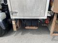 A 2008 Mitsubishi Fuso FE180 revealing its undercarriage showing a rusted metal frame and black batteries mounted on a metal platform