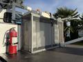 A 2011 International 7500 truck with a metal cage structure on the bed containing equipment and a mounted fire extinguisher